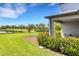 Inviting backyard featuring a well-manicured lawn, lush shrubbery, and a tranquil view of the pond at 8355 Velda Trl, Sarasota, FL 34241
