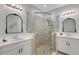 Bathroom featuring dual sinks, framed mirrors, and glass enclosed shower with pebble floor at 8355 Velda Trl, Sarasota, FL 34241