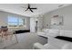 Bright bonus room with grey walls, neutral carpet, ceiling fan, and white sofa at 8355 Velda Trl, Sarasota, FL 34241