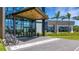 Exterior view of the clubhouse entrance featuring glass doors and a modern architectural style at 8355 Velda Trl, Sarasota, FL 34241