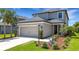 Close up exterior view showing a two-car garage and a manicured lawn at 8355 Velda Trl, Sarasota, FL 34241