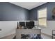 Bright home office featuring blue walls, white trim, a neutral desk, and a large window at 8355 Velda Trl, Sarasota, FL 34241