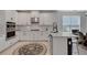 Bright kitchen with an island, white cabinets, stainless steel appliances, and tile flooring at 8355 Velda Trl, Sarasota, FL 34241