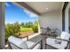 Stylish covered patio with outdoor seating, landscaping, and views of the lush backyard at 8355 Velda Trl, Sarasota, FL 34241