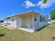 Property exterior showing a covered patio area, small grassy yard, and neutral siding at 8404 Imperial Cir # 8404, Palmetto, FL 34221