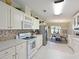 Bright kitchen featuring white cabinetry, modern appliances, and a view to an adjacent dining area at 8404 Imperial Cir # 8404, Palmetto, FL 34221