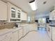 Bright kitchen featuring white cabinetry, tile backsplash, modern appliances, and an open view to the adjacent living area at 8404 Imperial Cir # 8404, Palmetto, FL 34221