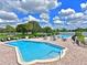 Outdoor community pool with surrounding lounge area, tables, and seating under sunny skies at 8404 Imperial Cir # 8404, Palmetto, FL 34221