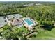 Aerial view highlighting a pool, tennis courts, and clubhouse, offering a variety of recreational amenities within the community at 8630 51St E Ter, Bradenton, FL 34211