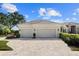 Wide driveway leading to a two-car garage nestled into a well-landscaped single-story home at 8630 51St E Ter, Bradenton, FL 34211