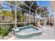 Relaxing hot tub set within a screened patio, surrounded by lush tropical landscaping and comfortable seating, creating a private oasis at 8630 51St E Ter, Bradenton, FL 34211