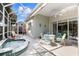 Inviting screened patio features a hot tub and outdoor dining area with comfortable seating, perfect for relaxation and entertaining at 8630 51St E Ter, Bradenton, FL 34211