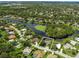 An aerial view showcases a lakefront home with beautiful landscaping in a desirable neighborhood at 8687 Woodbriar Dr, Sarasota, FL 34238