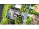 An aerial view of a home, with a screened-in pool, lush landscaping and a lake nearby at 8687 Woodbriar Dr, Sarasota, FL 34238