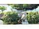 Beautiful aerial view of a single Gathering home on the water with lush landscaping and a screened in pool at 8687 Woodbriar Dr, Sarasota, FL 34238