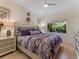 Bright bedroom featuring a decorative headboard and peaceful garden view at 8687 Woodbriar Dr, Sarasota, FL 34238