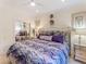 A bedroom with a stylish purple comforter set, a ceiling fan and a mirrored closet at 8687 Woodbriar Dr, Sarasota, FL 34238