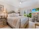 Inviting bedroom with a large bed, wooden floors, and a view of the greenery outside at 8687 Woodbriar Dr, Sarasota, FL 34238
