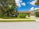 Beautifully landscaped home with three-car garage, mature trees, and an inviting facade at 8687 Woodbriar Dr, Sarasota, FL 34238