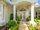Welcoming front entrance featuring double doors, columns and lush landscaping at 8687 Woodbriar Dr, Sarasota, FL 34238