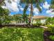 This landscaped front yard features lush tropical plants, offering great curb appeal at 8687 Woodbriar Dr, Sarasota, FL 34238