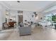 Elegant living room with a white piano, hardwood floors, and large sliding windows at 8687 Woodbriar Dr, Sarasota, FL 34238