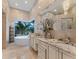 A luxurious bathroom featuring a modern freestanding tub with a garden view and elegant marble countertops at 8687 Woodbriar Dr, Sarasota, FL 34238