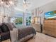 Elegant main bedroom features plush bedding, stylish dresser, and views of the pool at 8687 Woodbriar Dr, Sarasota, FL 34238