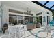 Covered patio with ceiling fan, dining table, and wicker furniture offers an enjoyable outdoor living space at 8687 Woodbriar Dr, Sarasota, FL 34238