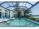 Enjoy a swim in the screened-in pool with mature landscaping and water views at 8687 Woodbriar Dr, Sarasota, FL 34238