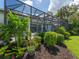Screened-in pool area with lush landscaping, blending indoor and outdoor living spaces for relaxation at 8687 Woodbriar Dr, Sarasota, FL 34238