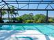 A screened-in pool area showcases a beautiful pool with fountain feature and mature landscaping at 8687 Woodbriar Dr, Sarasota, FL 34238