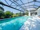 This screened-in pool offers a tranquil setting with mature landscaping and a fountain feature at 8687 Woodbriar Dr, Sarasota, FL 34238