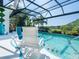 Relax on poolside lounge chairs in this screened-in pool area overlooking lush landscaping at 8687 Woodbriar Dr, Sarasota, FL 34238