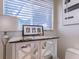 A cozy powder room featuring a mirrored vanity with marble countertops, a stylish lamp, and framed photos at 8687 Woodbriar Dr, Sarasota, FL 34238