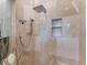 An elegant walk-in shower with a rainfall showerhead, bench, and niche in neutral marble tones at 8687 Woodbriar Dr, Sarasota, FL 34238
