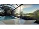 Relax and unwind in this screened-in pool area with serene lake views and comfortable lounge chairs at 8687 Woodbriar Dr, Sarasota, FL 34238