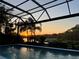 Enjoy the sunset from this screened-in swimming pool with lake views and mature trees at 8687 Woodbriar Dr, Sarasota, FL 34238
