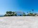 Charming, large blue house on sandy lot, complemented by mature palm trees at 894 Freeling Dr, Sarasota, FL 34242