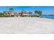 Expansive sandy property lot with multiple houses, lush palm trees, and scenic water view at 894 Freeling Dr, Sarasota, FL 34242