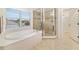 Bright bathroom featuring soaking tub, glass-enclosed shower, and natural light at 9307 Raes Creek Pl, Palmetto, FL 34221