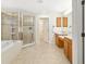 Bathroom featuring a soaking tub, glass enclosed shower, and dual sink vanity at 9307 Raes Creek Pl, Palmetto, FL 34221