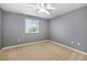 Bedroom showcasing neutral carpet, a ceiling fan, and a window providing natural light at 9307 Raes Creek Pl, Palmetto, FL 34221