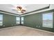 This bright bedroom has calming green walls, large windows, and a ceiling fan at 9307 Raes Creek Pl, Palmetto, FL 34221