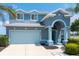 Two-story home boasts beautiful blue paint, manicured landscaping, and a large garage at 9307 Raes Creek Pl, Palmetto, FL 34221