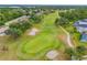 Aerial view of the community golf course with mature trees, sand traps, and manicured greens at 9307 Raes Creek Pl, Palmetto, FL 34221