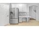 Kitchen with stainless steel refrigerator, white cabinetry, and mosaic backsplash at 9307 Raes Creek Pl, Palmetto, FL 34221