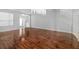 An airy living room with hardwood floors, an elegant chandelier and natural light from the windows at 9307 Raes Creek Pl, Palmetto, FL 34221