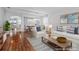 Bright living room with wood floors, white sofas, and a dining area is ideal for entertaining at 9307 Raes Creek Pl, Palmetto, FL 34221