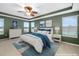 Comfortable main bedroom with a ceiling fan, an ensuite, and large windows overlooking the property at 9307 Raes Creek Pl, Palmetto, FL 34221